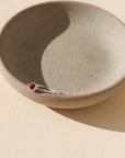 sterling silver bezel ring with 4mm ruby gemstone on a light dish