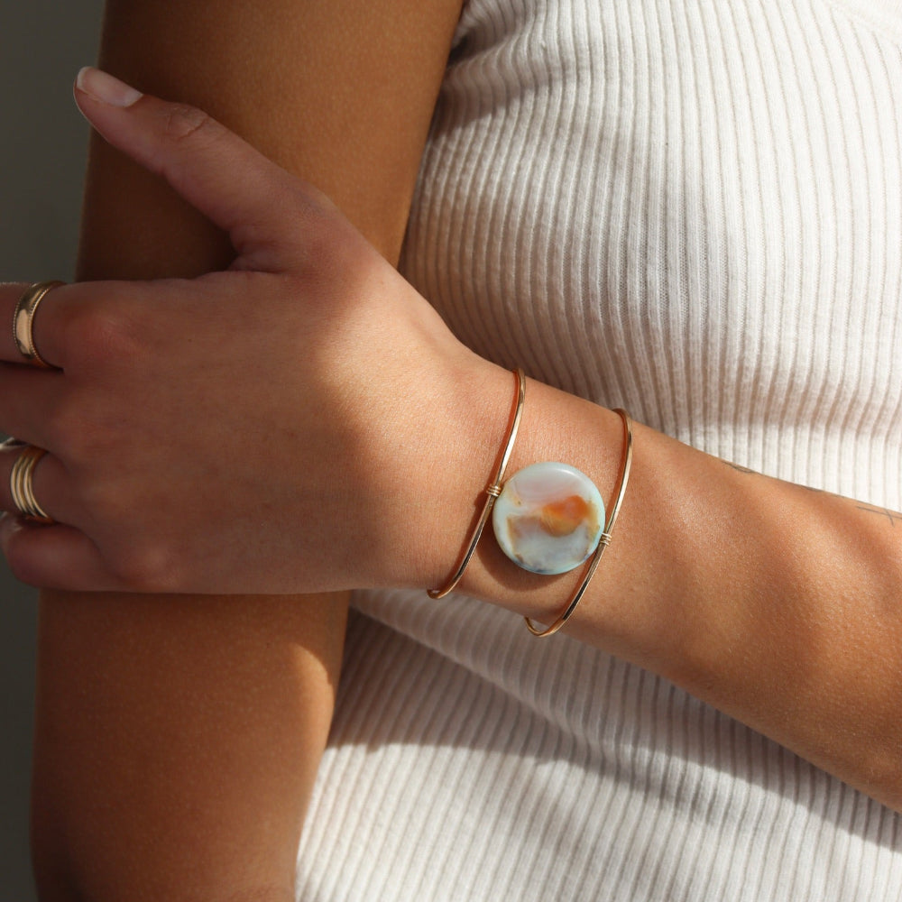 Model wearing the siren cuff. It features a Terra Agate Gemstone wire wrapped to a 14k gold fill wide cuff.