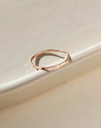 14k gold fill skinny ring laid on a white dish