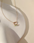 lightly hammered 14k solid gold circle pendent with dainty chain and colorful birthstone beads laid in the sunlight
