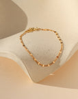 Gold sunburst chain bracelet with delicate textured links that catch the light.