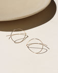 14k gold fill threader earrings on a light surface with a neutral background