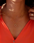 model wearing spiral wire heart shaped pendent necklace in 14k gold fill layered with 14k gold fill chain necklace