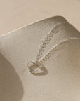 sterling silver spiral wire heart shaped pendent on simple sterling silver chain in the sunlight