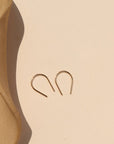 14k gold fill small horseshoes in sunlight