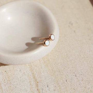 14k gold fill Opal Studs laid on a white plate in the sunlight.  - Token Jewelry