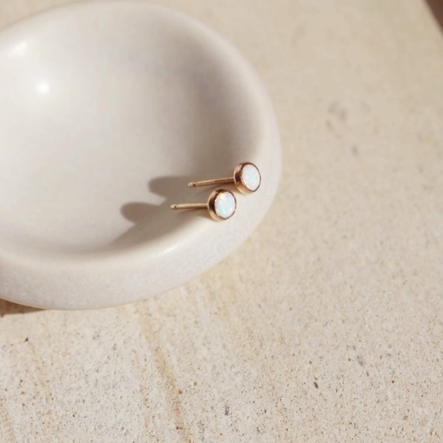 14k gold fill Opal Studs laid on a white plate in the sunlight.  - Token Jewelry