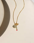 14k gold fill chain necklace with a dice charm, matchstick charm, and a 777 charm