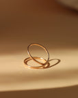 14k gold fill infinity ring laid on a tan plate. 
