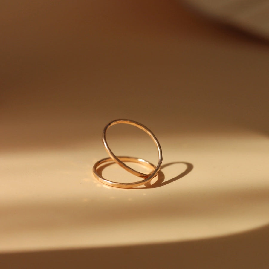 14k gold fill infinity ring laid on a tan plate. 