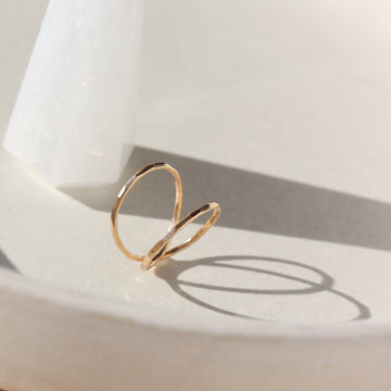 14k gold fill infinity Ring laid on a white plate. 