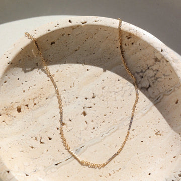 14k gold fill Sailor Chain set on a tan plate in the sunlight. - Token Jewelry