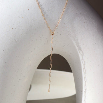14k solid gold necklace laid across white pot. Handmade in Eau Claire Wisconsin.