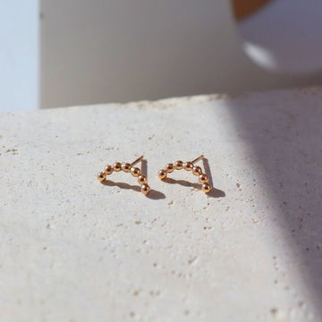 gold sequin arc studs | handmade by Token Jewelry in Eau Claire, Wisconsin. This earring features a stud like earring with an arc type shape. This arc features the sequin wire featured in multiple other pieces.- token jewelry