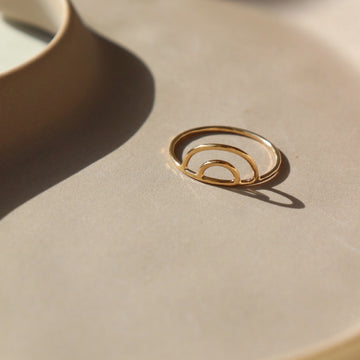 14k gold fill Rainbow Ring ring place on a tan plate in the sunlight.