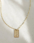 14k gold fill Everly Monogram Necklace placed on a white plate. Cosette linked chain - Gold or Sterling Silver Rectangle Hammered edge - Monogrammed with letter - Jewelry near me - Eau Claire
