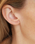 Model wearing 14k gold fill Swell Studs -These earring are a perfect stud to layer with your other token earrings. This earring give the allusion of a little "s".