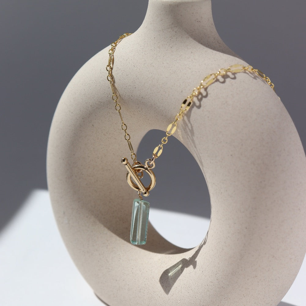 14k gold fill Flynn Toggle Necklace. This Necklace Features a Simple Toggle connector with a Dangle Fluorite tube gemstone . The toggle is held together with the Sylvie chain.