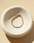 Summit Ring laid on a white plate in the sunlight