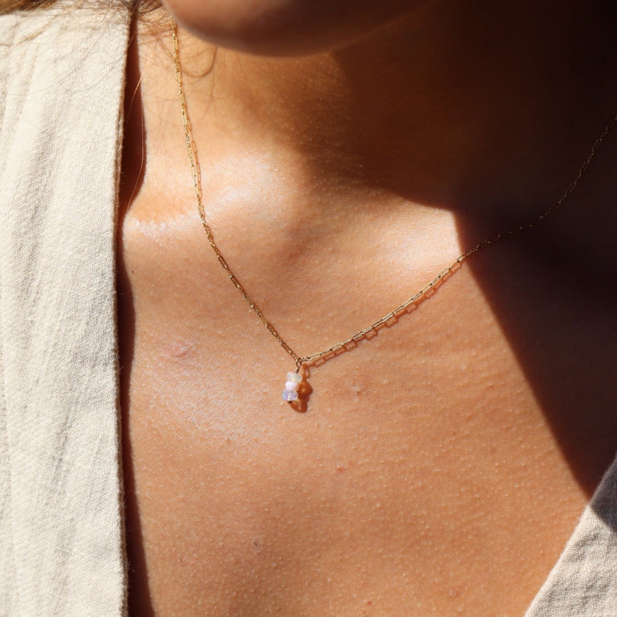 Model wearing 14k gold fill Gender Reveal Necklace. This necklace features a beautiful mini paper clip chain that is met together with either a pink or blue opal gemstones.