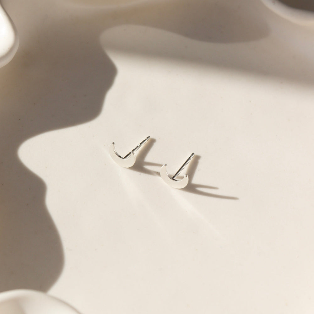 Tiny moon studs in sterling silver by Token Jewelry