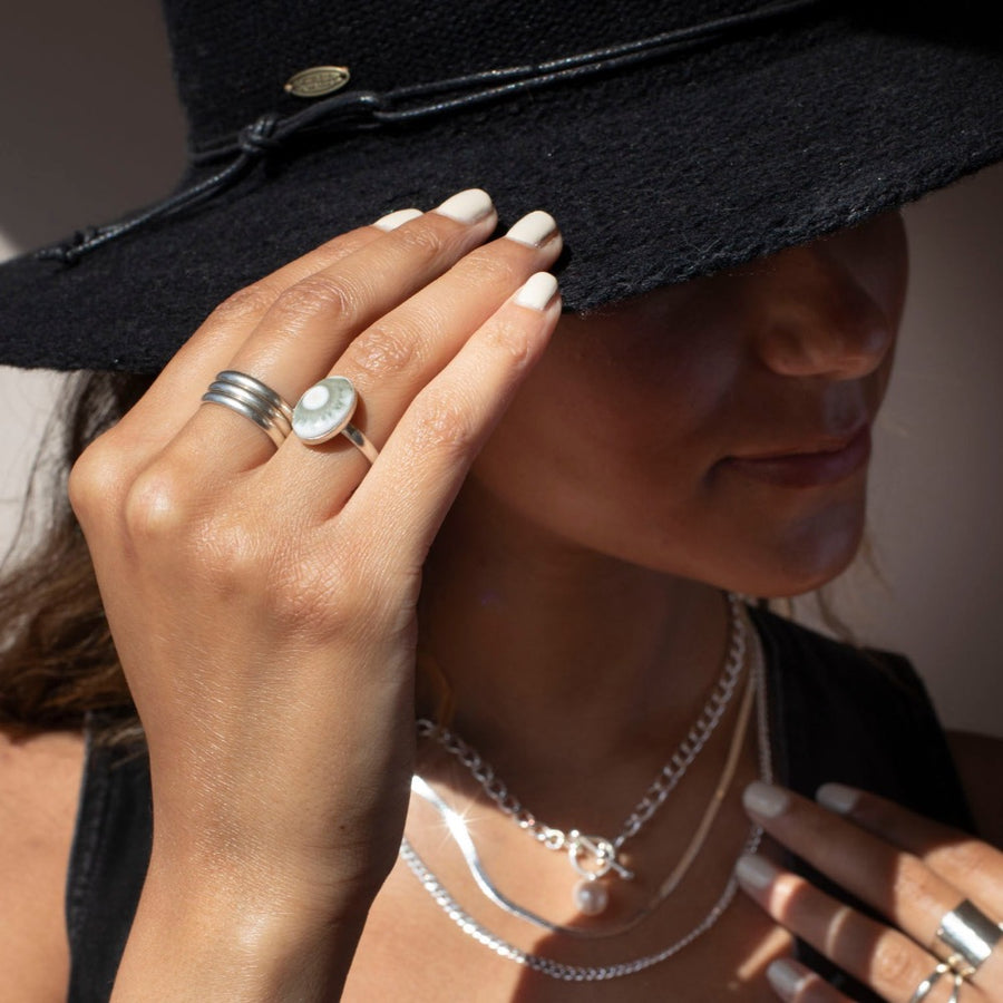 a 14k gold fill hand-set ocean jasper ring photographed on a model wearing silver jewelry and a black cowboy hat
