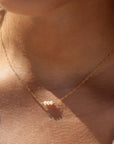 three freshwater pearls lined up on a 14k gold fill simple chain, made by Token Jewelry, photographed on a model