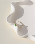 4mm Jade Gemstone Ring set in a 14k gold fill bezel with simple hammered ring band. The Ring is sitting on a white ceramic plate.