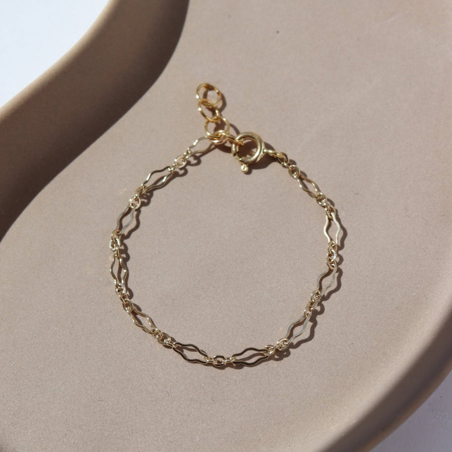 Children's size delicate curvy chain linked bracelet in 14k gold fill. Spring hook clasp closure and half inch extender to make the bracelet adjustable. Handmade by Token Jewelry in Eau Claire, WI
