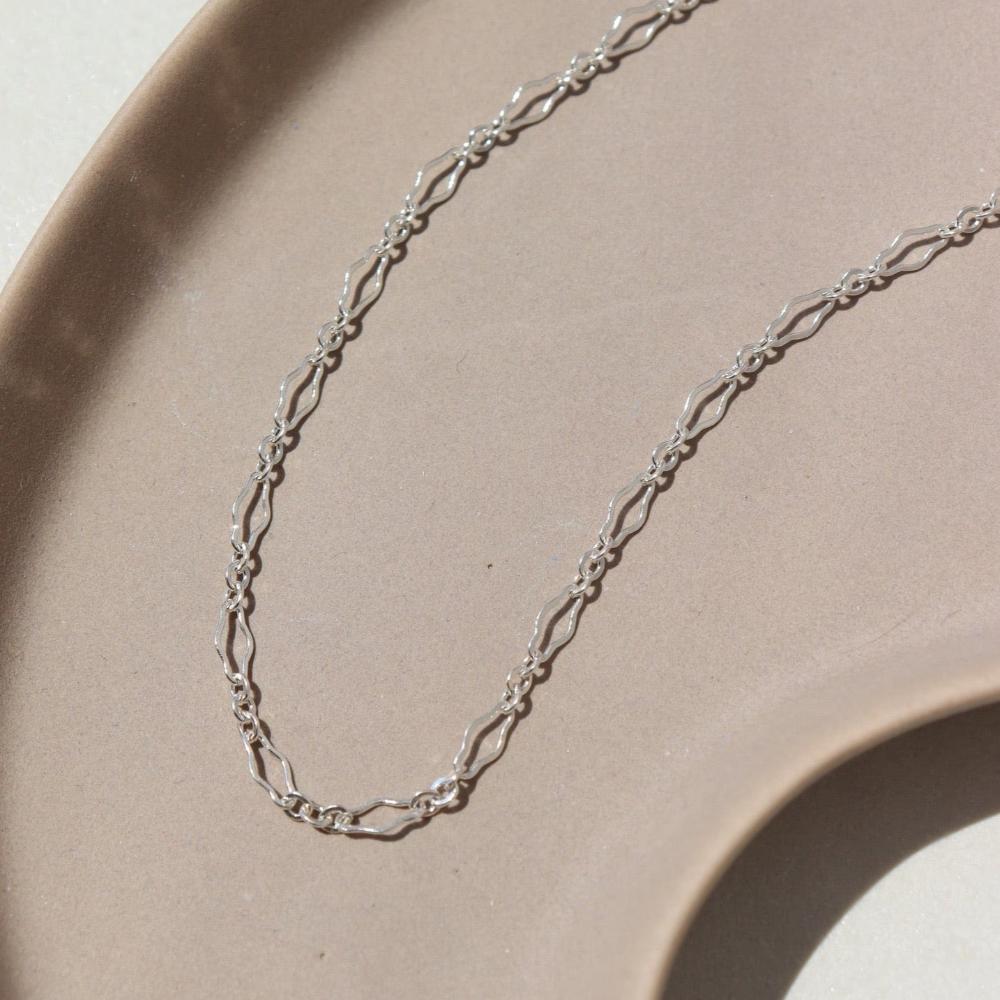925 Sterling silver Clara Bracelet laid on a tan plate