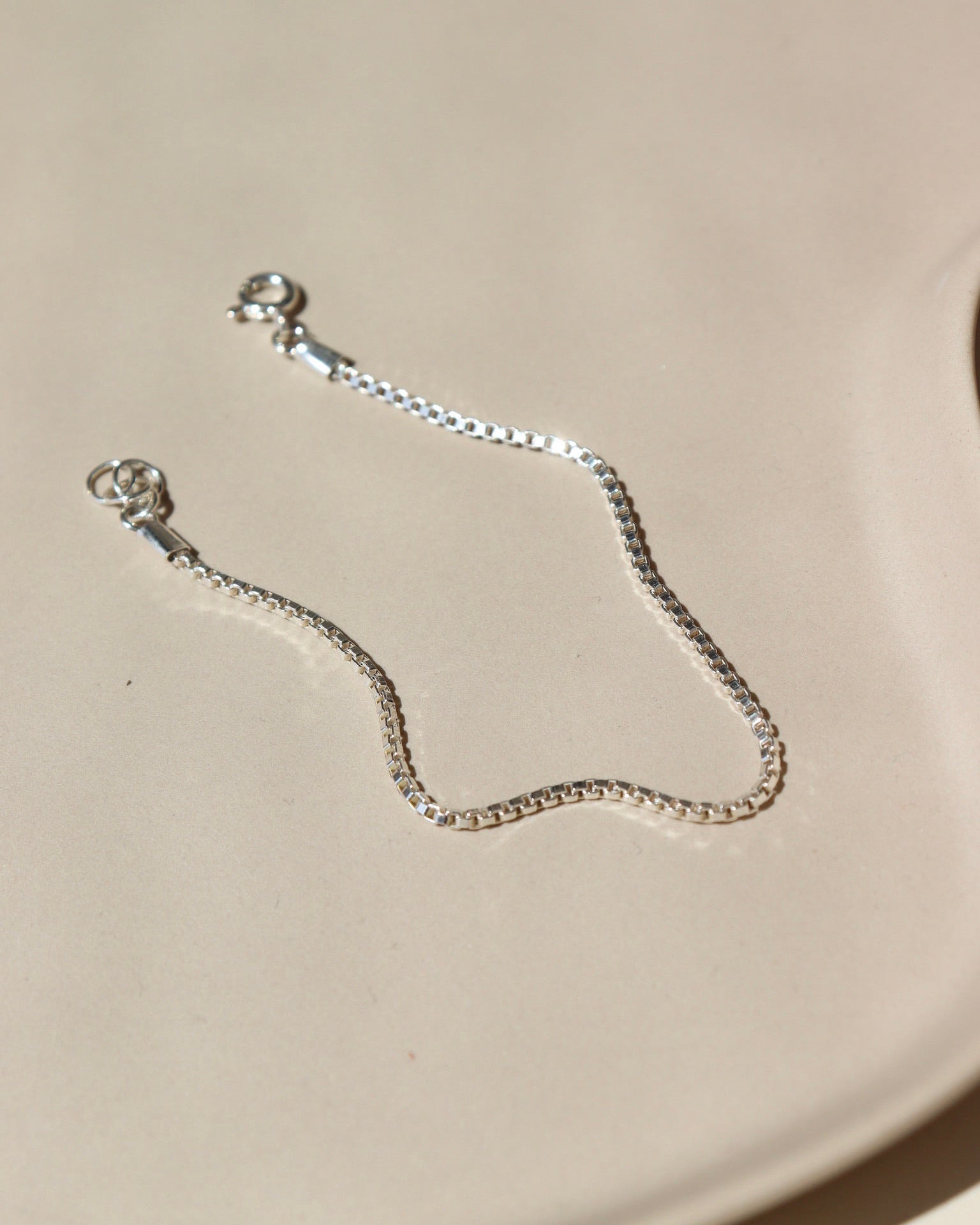925 sterling silver bracelet laid on a tan paper in the sunlight