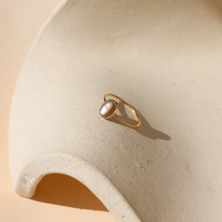 14k gold fill  ring with handset abalone stone on a light dish