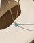 Amazonite donut shaped gemstone pendant attached to a 14k gold Fill chain in the sunlight