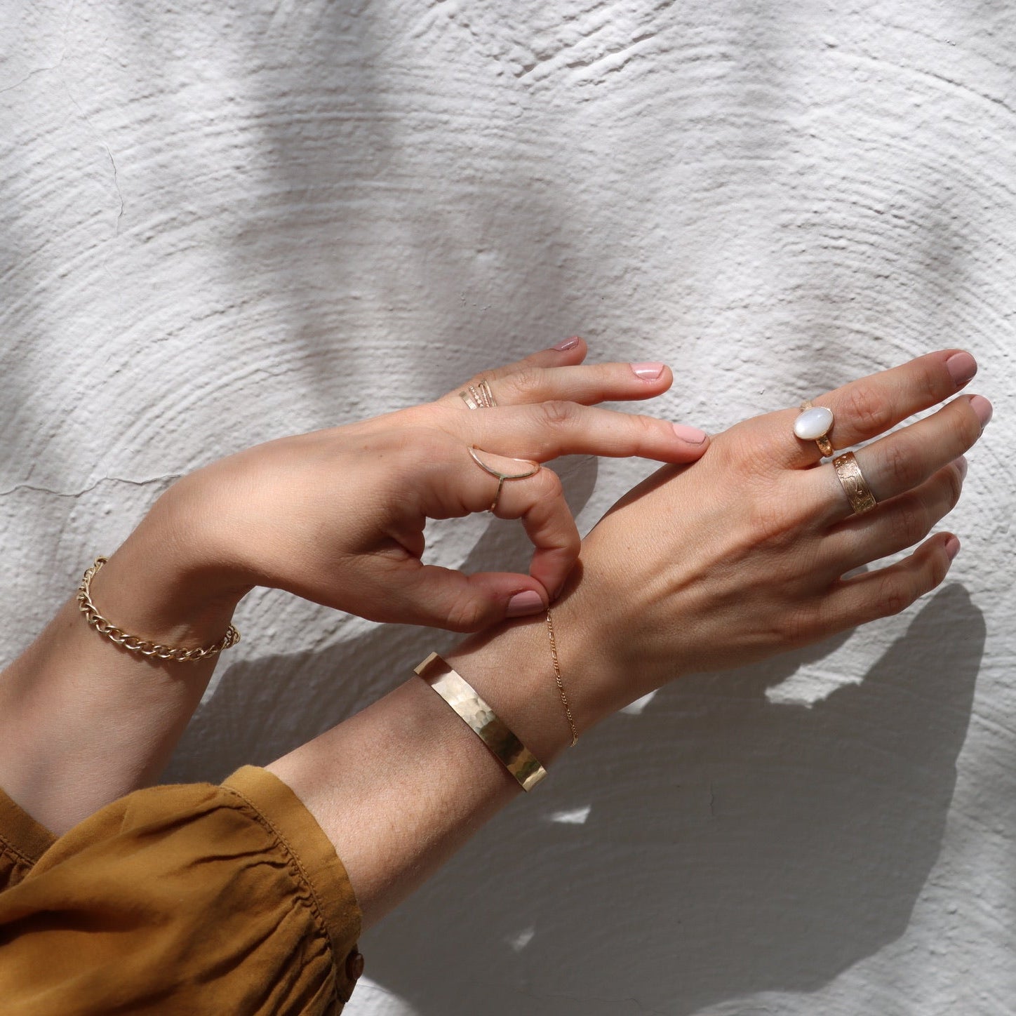 model wearing 14k gold fill delicate figaro chain bracelet with hammered cuff bracelet