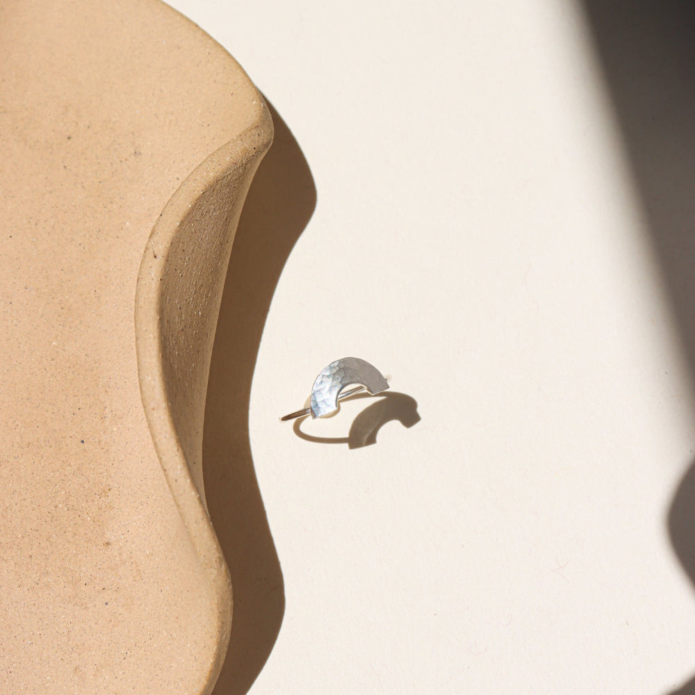 Curved hammered stacking ring in sterling silver with a rainbow-like arc shape