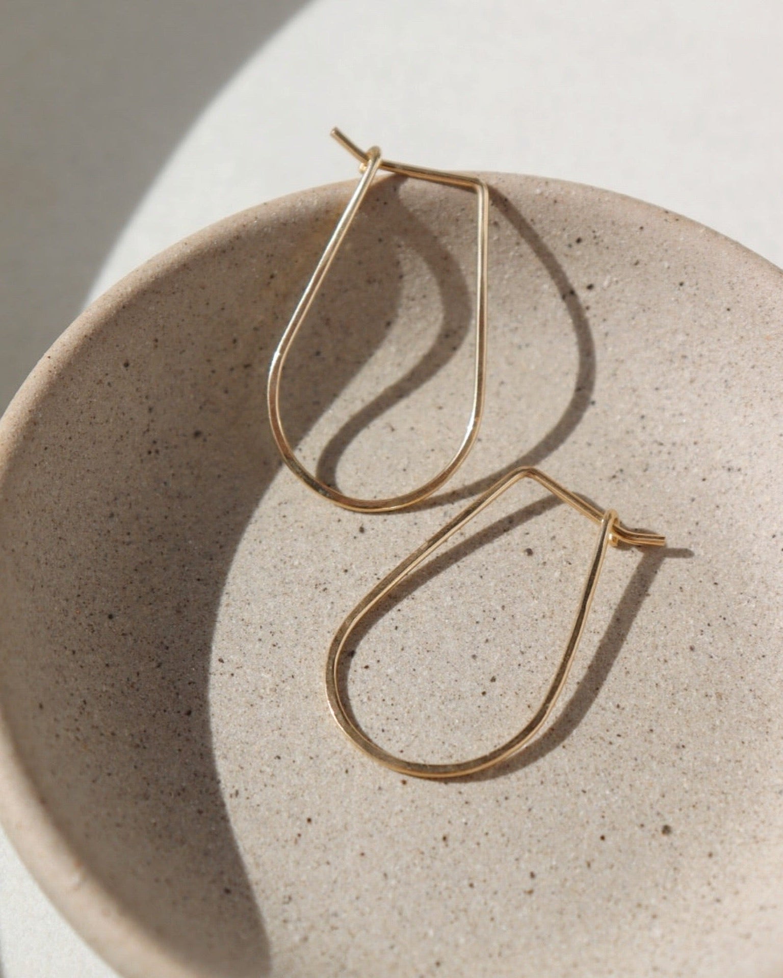 solid gold athena hoops, solid gold hoops, hand hammered solid gold, handmade jewelry, made in the USA, made in wisconsin, woman owned business, classic hoops, classic gold hoops, effortless jewelry, timeless gold jewelry.