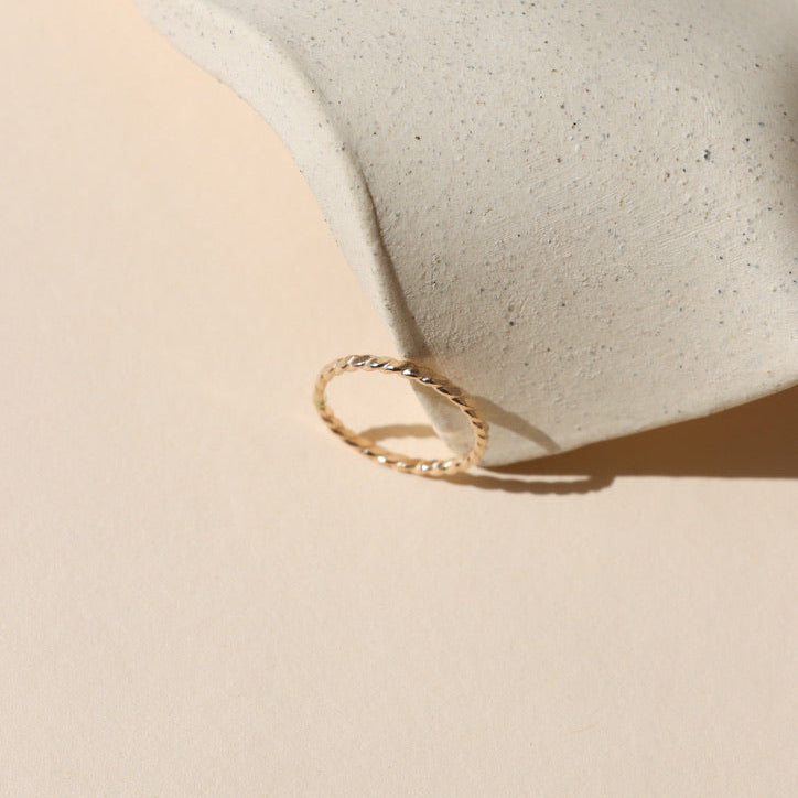 14k gold fill hammered spiral wire rings on a light dish