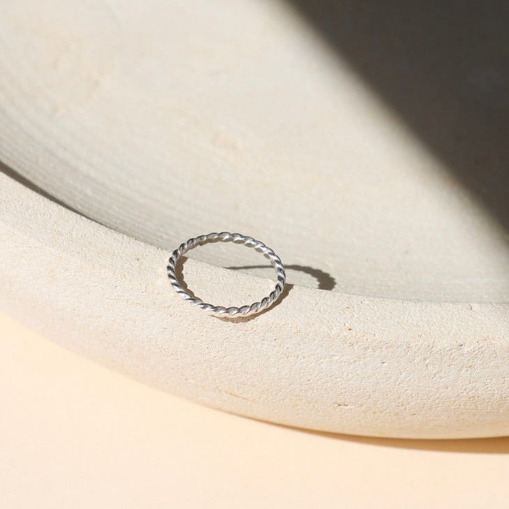 sterling silver hammered spiral wire rings on a light dish