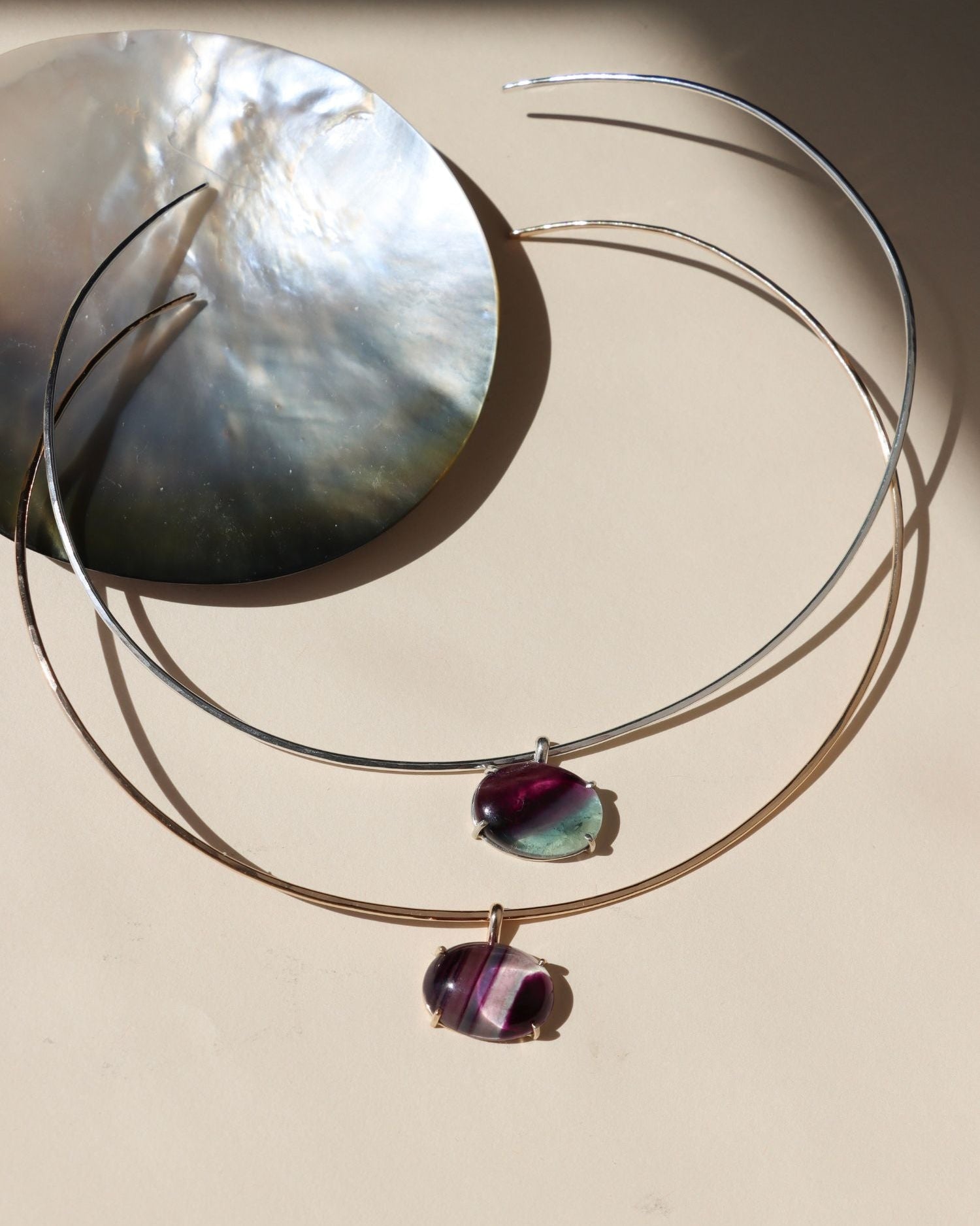 sterling silver and 14k gold fill wire collarbone necklace with handset fluorite stone in a bezel on a light dish