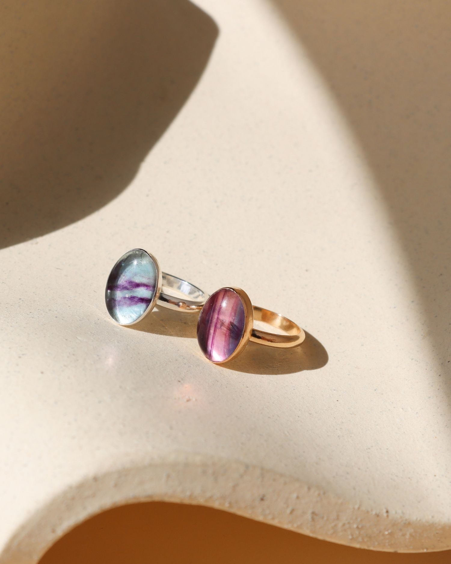 sterling silver and 14k Gold Fill rings with handset fluorite stones on a light dish