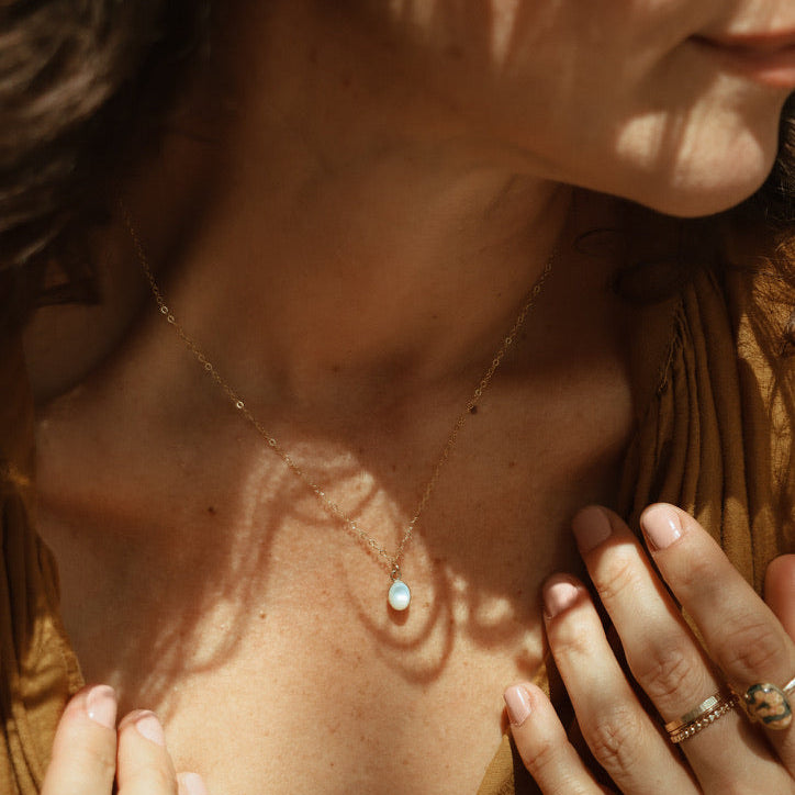 model wearing 14k gold fill delicate chain necklace with oval mother of pearl stone