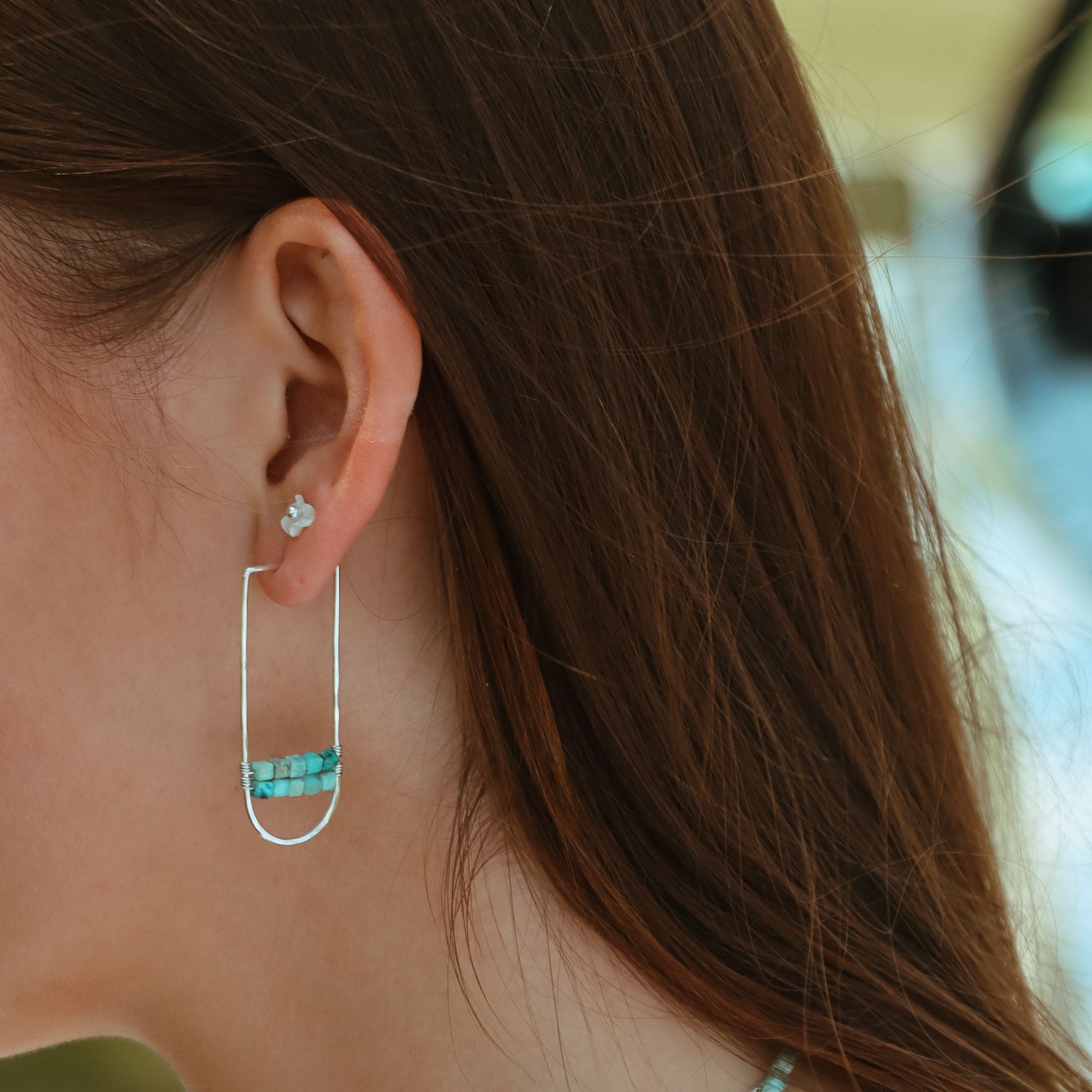 model wearing sterling silver hoops with turquoise accents