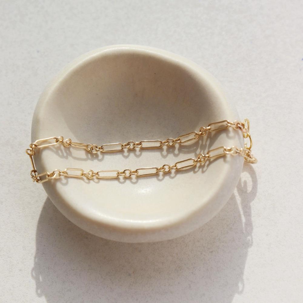 Callie Bracelet by token jewelry on a white ring dish