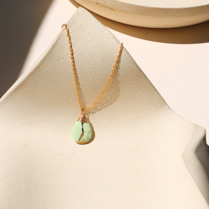 14k gold fill chain necklace with wire wrapped lemon chrysoprase stone on a light dish