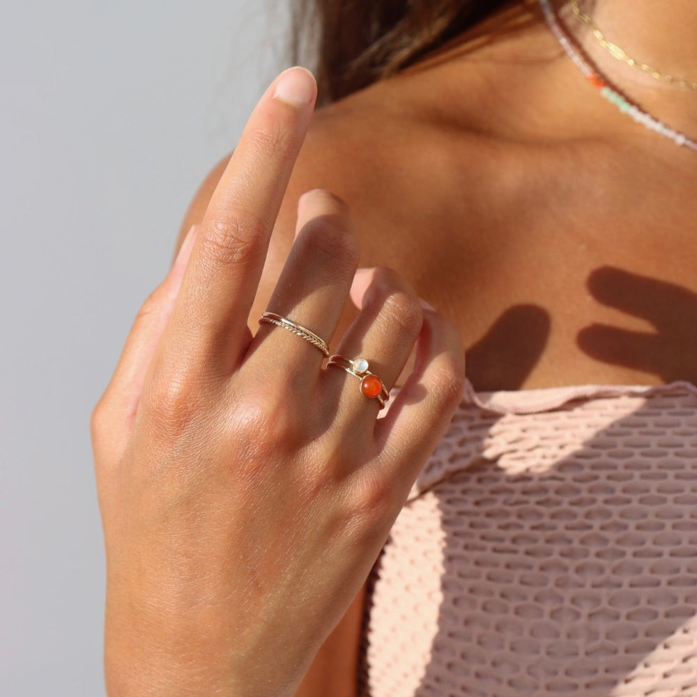 Model wearing fiery carnelian glow ring in gold fill setting