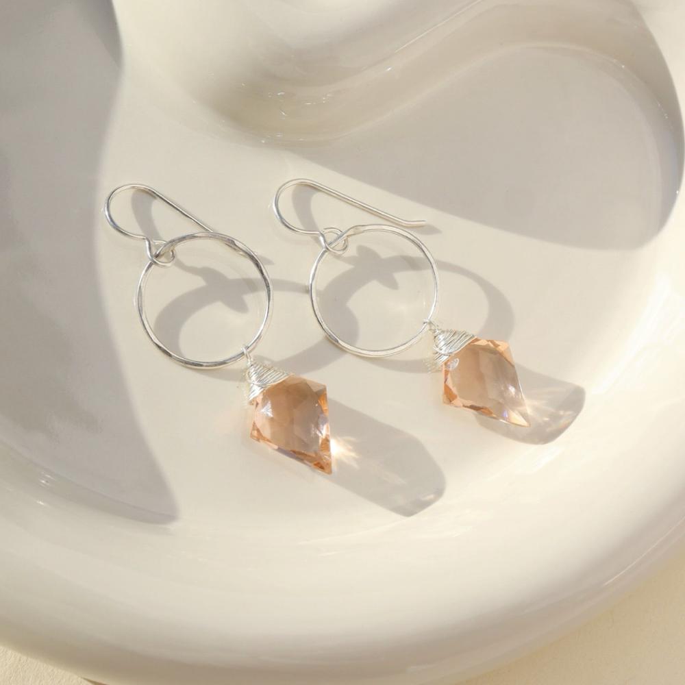 sterling silver earrings with rose quartz charms on a light dish