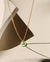 Chrysoprase donut shaped gemstone pendant attached to a 14k gold Fill chain in the sunlight