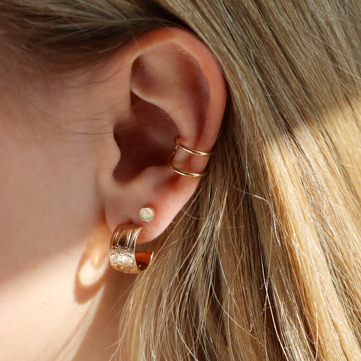 model wearing 14k gold fill textured hoops with ear cuff and gemstone studs