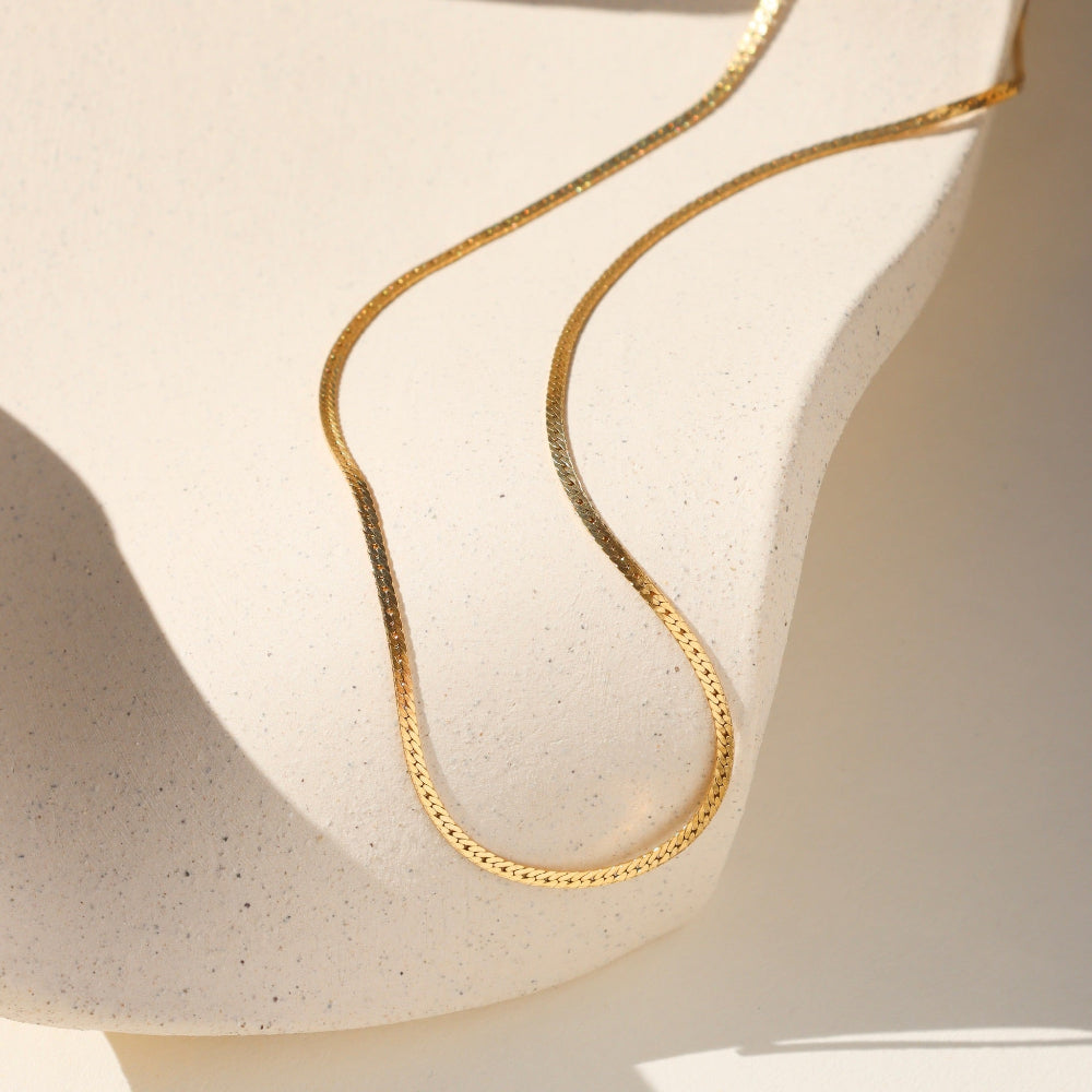 14k gold fill herringbone chain necklace on a light dish