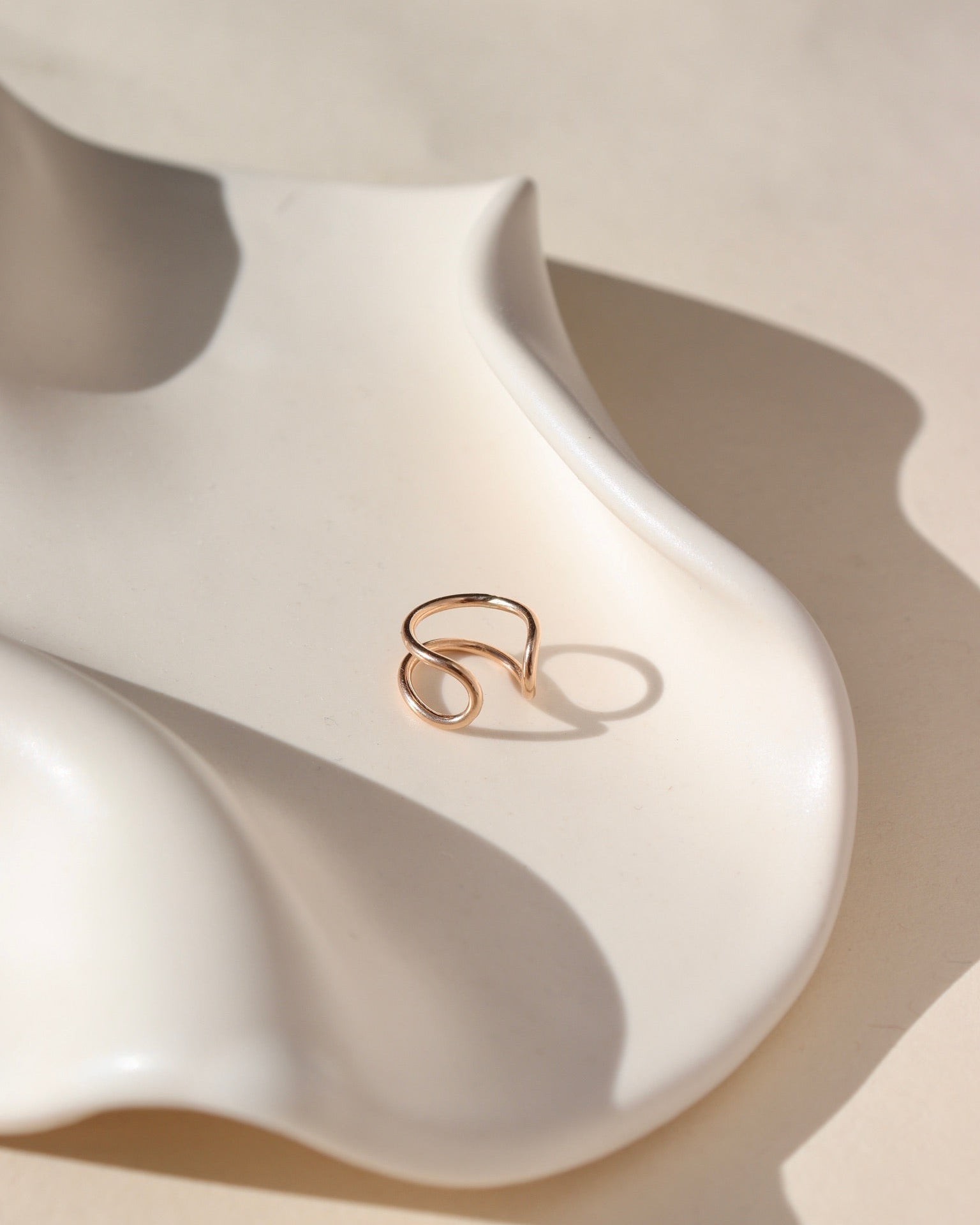 14k gold fill classic ear cuff on wavy dish in the sunlight
